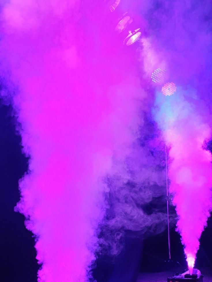 Humo de la máquina iluminado en rosa sobre la pista de baile
